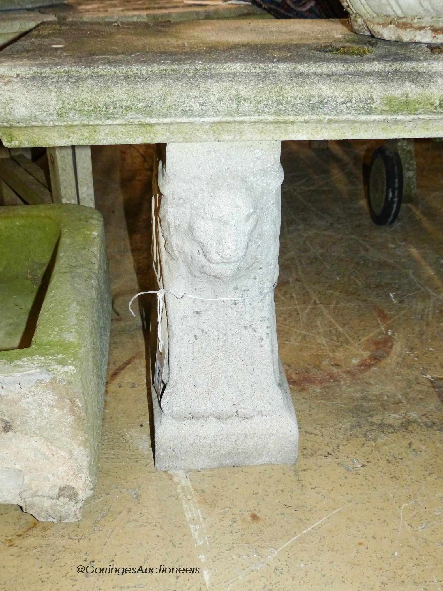 A reconstituted stone bench, with moulded rectangular top on stylised lion end supports, width 126cm, depth 41cm, height 44cm